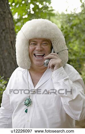Stock Photo - Eccentric guest at a wedding laughs on his cell phone in Ojai, CA. Fotosearch