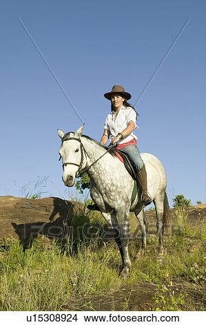 Picture - Female horseback rider and horse ride overlooking Lewa Wildlife Conservancy in North Kenya, Africa. Fotosearch