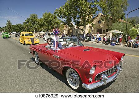 Stock Photo - Festive decorated vintage automobile makes its way down main street during a Fourth of July parade in Ojai, CA. Fotosearch