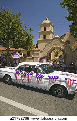Stock Photo - Festive decorated vintage automobile makes its way down main street during a Fourth of July parade in Ojai, CA. Fotosearch