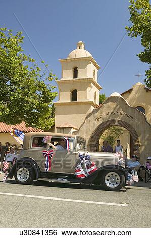 Stock Photograph - Festive decorated vintage Rolls Royce makes its way down main street during a Fourth of July parade in Ojai, CA. Fotosearch
