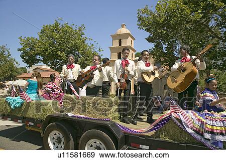 Stock Photo - Festive float with singing Mariachis makes its way down main street during a Fourth of July parade in Ojai, CA. Fotosearch