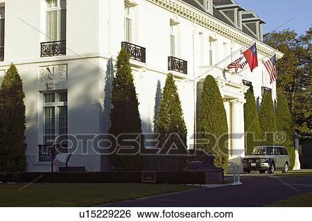 Stock Photograph - Flags hang over a Landrover auto parked in front of a mansion of Newport Rhode Island. Fotosearch