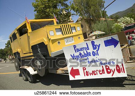 Picture - Float of a Hummer vehicle powered by vegetable oil with sign that reads "Powered By Oil" makes its way down main street during a Fourth of July parade in Ojai, CA. Fotosearch
