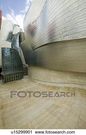 Front entrance of the Guggenheim Museum of Contemporary Art of Bilbao (Bilbo), located on the North Coast of Spain in the Basque region. Nicknamed "The Hole", this is a contemporary museum built of titanium, limestone and glass and was designed by Canadia View Large Photo Image Stock Image - Front entrance of the Guggenheim Museum of Contemporary Art of Bilbao (Bilbo), located on the North Coast of Spain in the Basque region. Nicknamed "The Hole", this is a contemporary museum built of titanium, limestone and glass and was designed by Canadia. Fotosearch