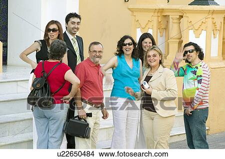 Picture - Group of smiling people near front of church in village of Southern Spain off highway A49 west of Sevilla. Fotosearch