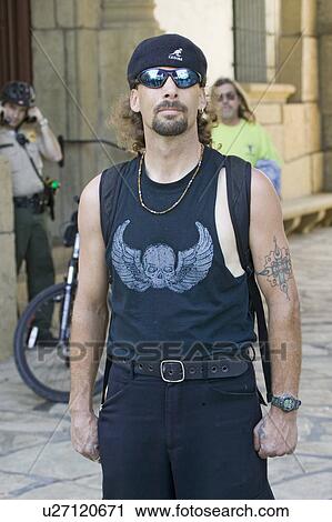 Stock Image - Hispanic man in black t-shirt, black beret and sunglasses looks into camera in Santa Barbara, California. Fotosearch