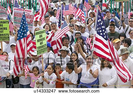 Stock Photo - Hispanics wave American flags as hundreds of thousands of immigrants participate in march for Immigrants and Mexicans protesting against Illegal Immigration reform by U. S. Congress, Los Angeles, CA, May 1, 2006. Fotosearch