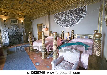 Stock Photograph - Interior of guest bedroom with displayed antique clothing of the day at Hearst Castle, "America's Castle, " San Simeon, Central California Coast. Fotosearch