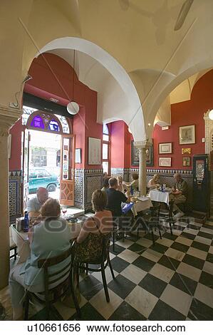 Stock Photograph - Interior view of restaurant and people having lunch in Sevilla Spain. Fotosearch