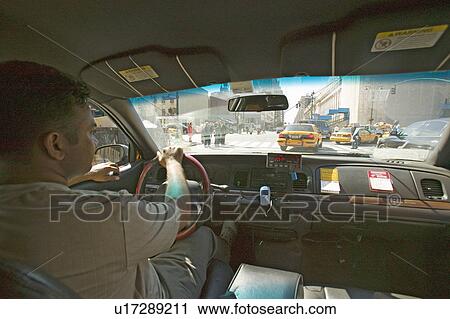 Interior view of taxi cab and driver steering through New York City, Manhattan streets, New York View Large Photo Image Stock Image - Interior view of taxi cab and driver steering through New York City, Manhattan streets, New York. Fotosearch