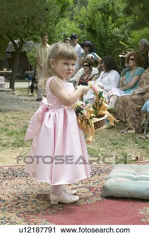 Stock Image - Little girl with basket of flowers at a traditional Jewish wedding in Ojai, CA. Fotosearch