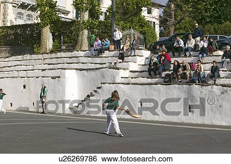 Stock Photograph - Local villagers in Sare, France, in Basque Country on the Spanish-French border, watch Jai Li game near St. Jean de Luz, on the Cote Basque, South West France. Fotosearch