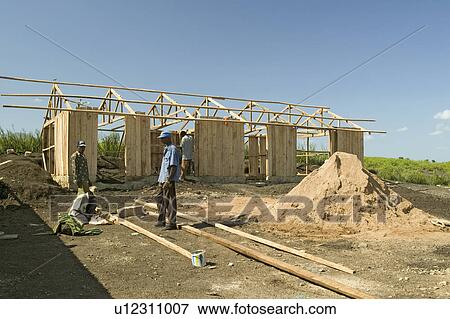 Man helps construct new houses for Pepo La Tumaini Jangwani, HIV/AIDS Community Rehabilitation Program, Orphanage & Clinic. Pepo La Tumaini Jangwani (wind of hope in the arid place) offers hope, support and care for orphan and vulnerable children living View Large Photo Image Stock Photo - Man helps construct new houses for Pepo La Tumaini Jangwani, HIV/AIDS Community Rehabilitation Program, Orphanage & Clinic. Pepo La Tumaini Jangwani (wind of hope in the arid place) offers hope, support and care for orphan and vulnerable children living . Fotosearch
