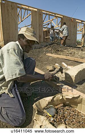 Stock Photography - Man helps construct new houses for Pepo La Tumaini Jangwani, HIV/AIDS Community Rehabilitation Program, Orphanage & Clinic. Pepo La Tumaini Jangwani (wind of hope in the arid place) offers hope, support and care for orphan and vulnerable children living . Fotosearch