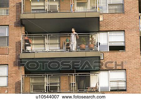 Man on balcony in t-shirt looks out from his New York City apartment in upper New York City, Third Avenue View Large Photo Image Stock Photo - Man on balcony in t-shirt looks out from his New York City apartment in upper New York City, Third Avenue. Fotosearch