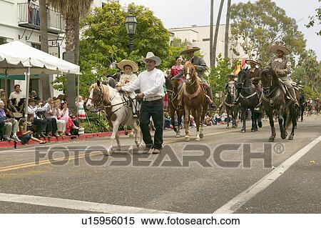 Stock Photography - Mexican horseback riders trot along during the opening day parade down State Street of Old Spanish Days Fiesta held every August in Santa Barbara, California. Fotosearch