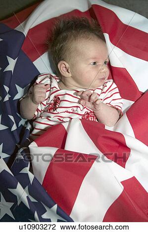 Stock Image - Newborn baby (Sophia Larson) wrapped in American flag was born on October 16th, the birthday of the 300 Millionth American, Ventura, California. Fotosearch
