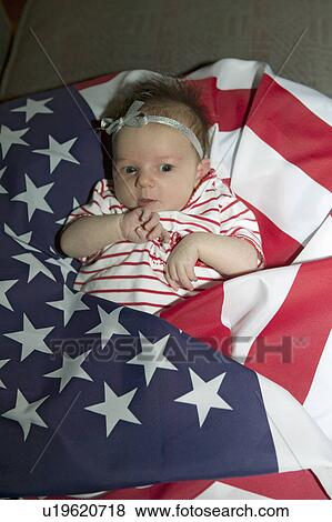 Stock Photo - Newborn baby (Sophia Larson) wrapped in American flag was born on October 16th, the birthday of the 300 Millionth American, Ventura, California. Fotosearch