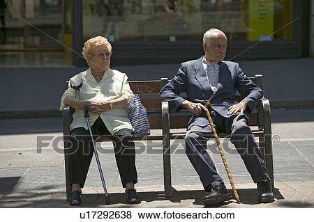 Stock Photo - Older man and women with canes sit on bench near La Rambla, Barcelona, Spain. Fotosearch
