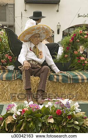 Stock Image - Older Mexican-American man sits on parade float at annual Old Spanish Days Fiesta held every August in Santa Barbara, California. Fotosearch