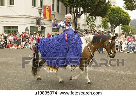 Older woman in purple dress, riding every year since 1924, rides again in 2006 on opening day at Old Spanish Days Fiesta held every August in Santa Barbara, California View Large Photo Image Picture - Older woman in purple dress, riding every year since 1924, rides again in 2006 on opening day at Old Spanish Days Fiesta held every August in Santa Barbara, California. Fotosearch