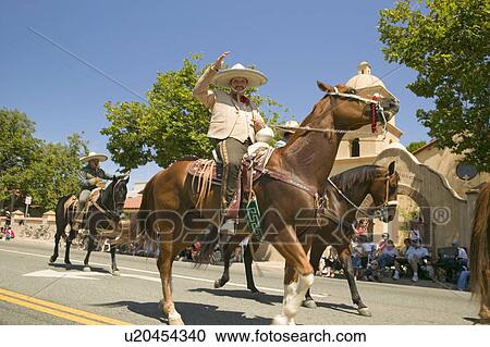 Stock Image - Parade participants on horseback make their way down main street during a Fourth of July parade in Ojai, CA. Fotosearch