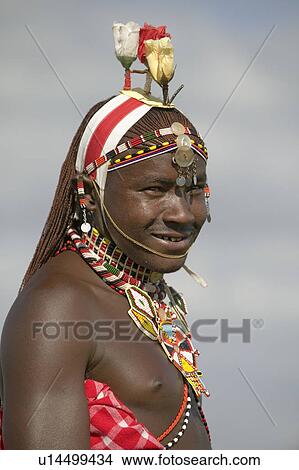 Picture - Portrait of Masai Warrior in traditional red toga and flowers on his head at Lewa Wildlife Conservancy in North Kenya, Africa. Fotosearch