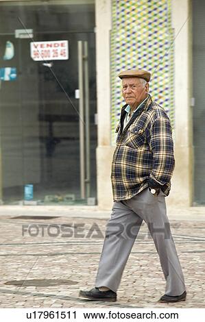 Stock Image - Portuguese man with hat stands in the historic town center of Tomar, Portugal. Fotosearch