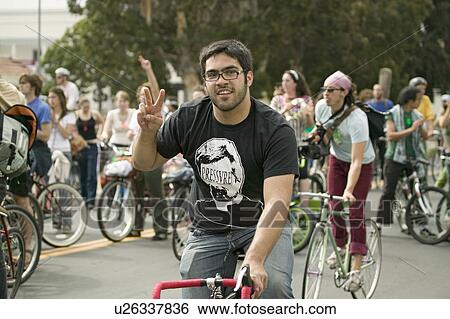 Stock Photograph - Protesters arrive on bicycle and give the peace sign at an anti-Iraq War protest march in Santa Barbara, California on March 17, 2007. Fotosearch