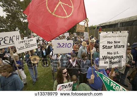 Protesters march with peace flag against President George W. Bush and the Iraq war at an anti-Iraq War protest march in Santa Barbara, California on March 17, 2007 View Large Photo Image Stock Photo - Protesters march with peace flag against President George W. Bush and the Iraq war at an anti-Iraq War protest march in Santa Barbara, California on March 17, 2007. Fotosearch