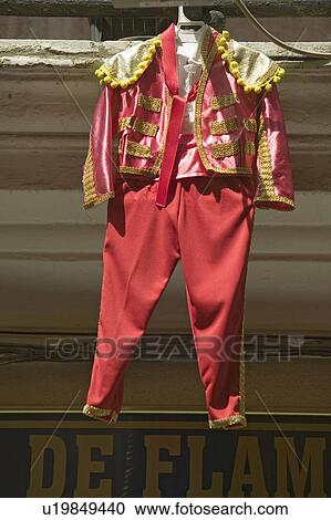 Red toreador bull fighting outfit for boy hangs in Centro old district of Sevilla Spain View Large Photo Image Stock Image - Red toreador bull fighting outfit for boy hangs in Centro old district of Sevilla Spain. Fotosearch