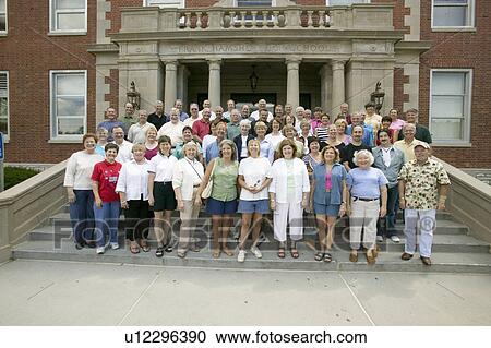 Stock Image - The Class of 1966" High School reunion 40th anniversary, pose in front of Webster Groves High School, in Webster Groves, St. Louis, Missouri. Fotosearch
