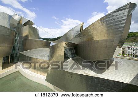 Stock Image - The Guggenheim Museum of Contemporary Art of Bilbao (Bilbo), located on the North Coast of Spain in the Basque region. Nicknamed "The Hole", this is a contemporary museum built of titanium, limestone and glass and was designed by Canadian citizen, Frank O. Fotosearch