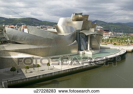 Stock Image - The Guggenheim Museum of Contemporary Art of Bilbao (Bilbo), located on the North Coast of Spain in the Basque region. Nicknamed "The Hole", this is a contemporary museum built of titanium, limestone and glass and was designed by Canadian citizen, Frank O. Fotosearch