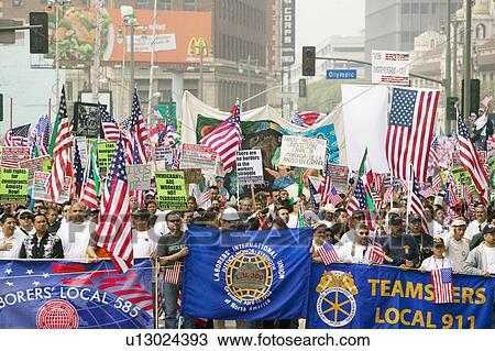 Stock Image - Union worker banners in front of hundreds of thousands of immigrants participating in march for Immigrants and Mexicans protesting against Illegal Immigration reform by U. S. Congress, Los Angeles, CA, May 1, 2006. Fotosearch