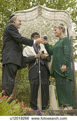 Wedding ceremony under a canopy with Rabbi, bride and groom at a traditional Jewish wedding in Ojai, CA View Large Photo Image Stock Photograph - Wedding ceremony under a canopy with Rabbi, bride and groom at a traditional Jewish wedding in Ojai, CA. Fotosearch