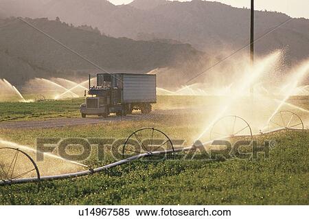 Semi truck in a farm field that is being watered View Large Photo Image Stock Photography - Semi truck in a farm field that is being watered. Fotosearch