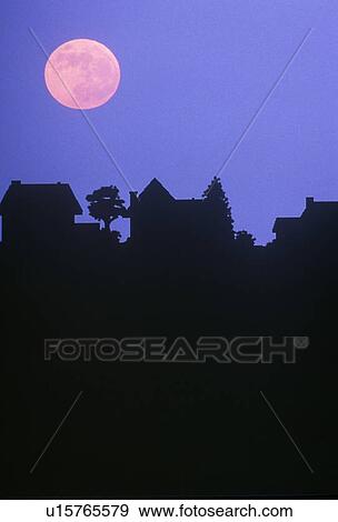 Stock Photo - Silhouette of full moon over family homes. Fotosearch