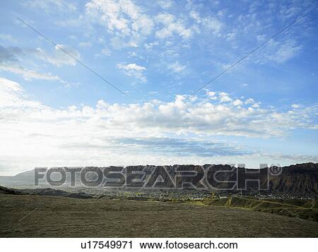 Stock Image - Clouds over rock strata, Moab, Utah, USA. Fotosearch
