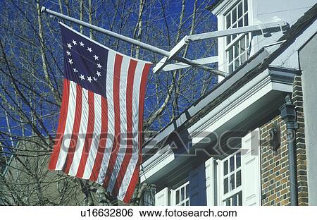 Stock Photograph - Original 13 colony flag flying outside home. Fotosearch
