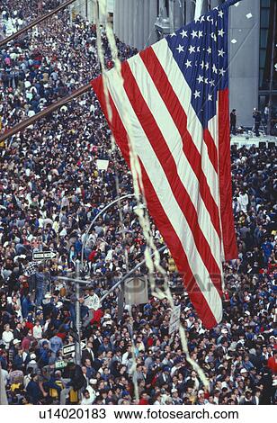 American flag flying over large crowd at tickertape parade View Large Photo Image Stock Image - American flag flying over large crowd at tickertape parade. Fotosearch