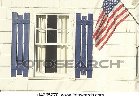 Stock Image - American Flag Hung on a White House. Fotosearch