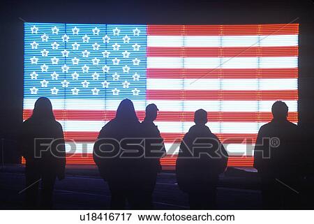 Stock Photo - Silhouettes of People in front of an American electric Flag. Fotosearch