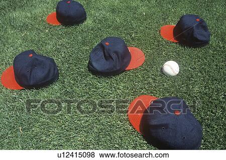 Baseball caps and ball on field View Large Photo Image Stock Photo - Baseball caps and ball on field. Fotosearch