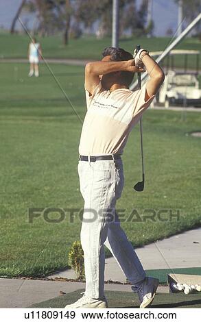 Golfer in mid-swing, Golf Retreat View Large Photo Image Stock Photo - Golfer in mid-swing, Golf Retreat. Fotosearch