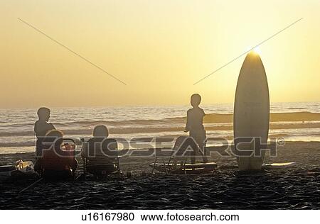 Silhouetted family on the beach at sunset View Large Photo Image Stock Image - Silhouetted family on the beach at sunset. Fotosearch