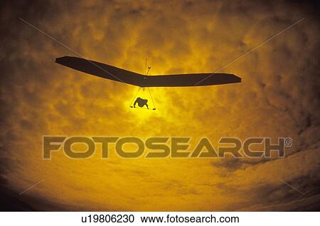 Stock Image - Solar Sailing Hang Gliding in sunset silhouette. Fotosearch