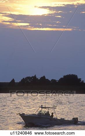 Stock Photograph - Sunset silhouette of fishing boat. Fotosearch