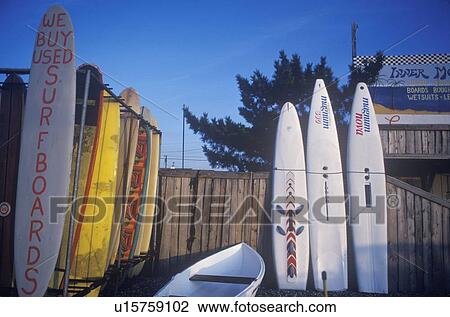 Stock Image - Surfboards lined up on wooden fence. Fotosearch